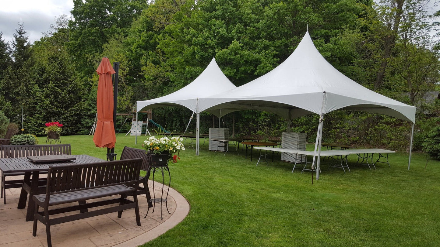 High peak frame tents on a lawn beside a patio at a backyard event