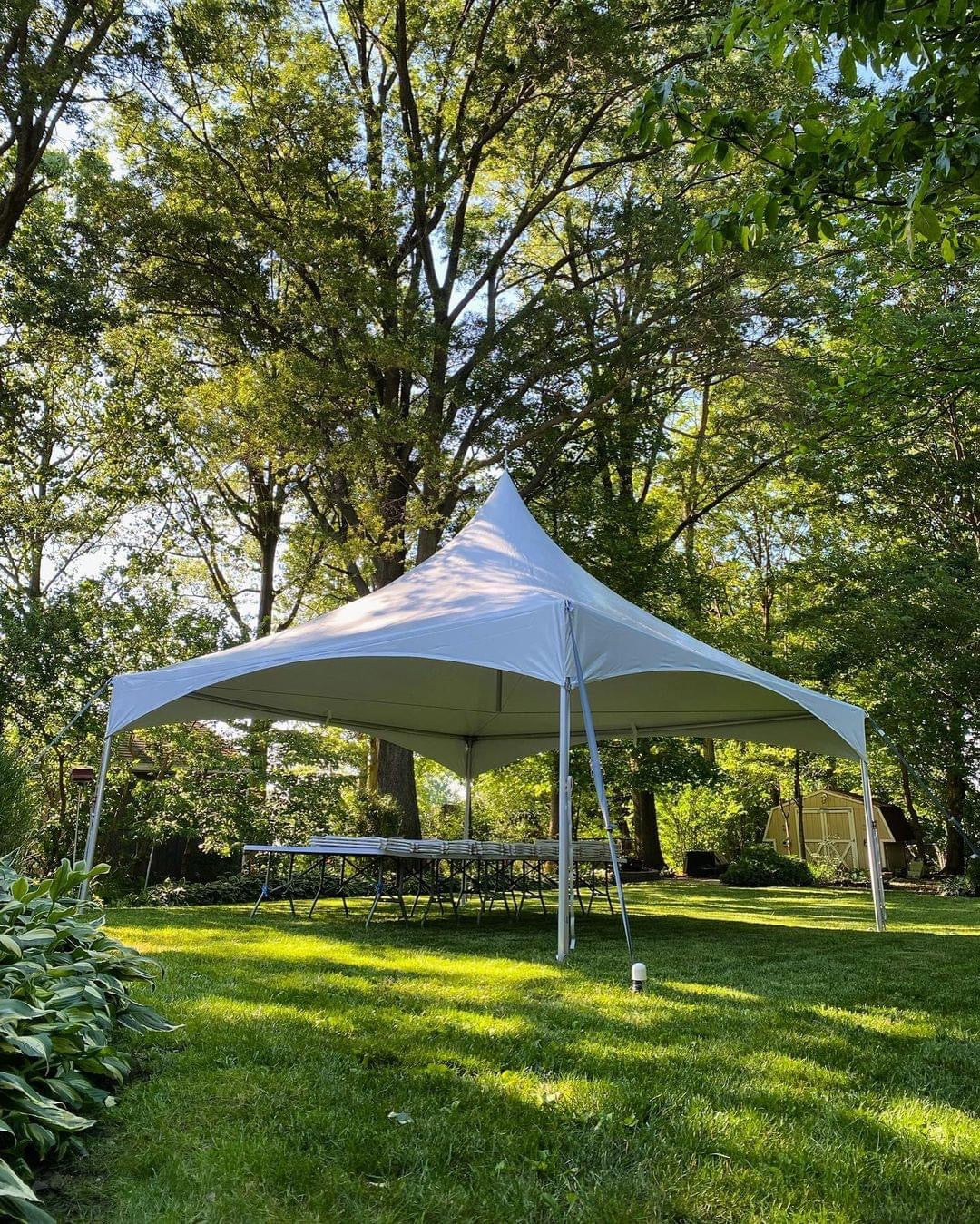 White 20x20 high peak frame tent on grass showing the clear span interior