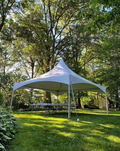 White 20x20 high peak frame tent on grass showing the clear span interior