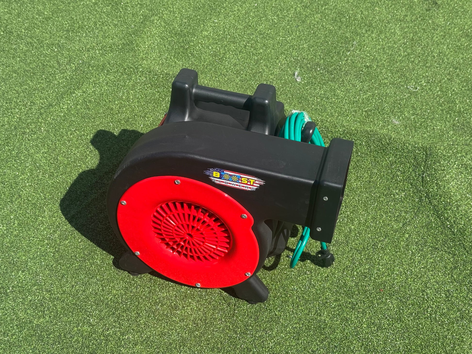 Inflatable air blower on turf with red fan housing and black body